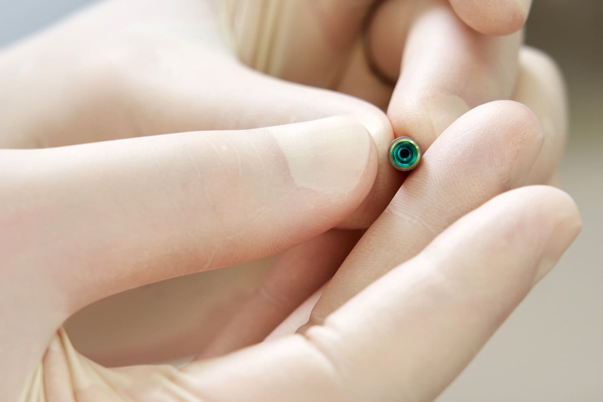 Имплант зуба в руке, видно размер